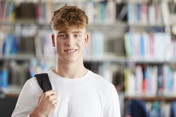 Portrait Of Male Student Standing In College Library