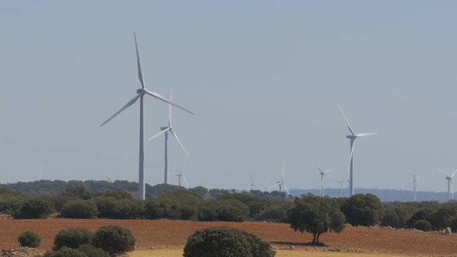 Wind Turbines in the Desert of Spain. Massive wind turbines generating power. Heat haze effect on desert land. Clean Energy producing of Windmills. Alternative power generation methods