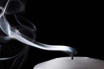Smoke and extinct candle on a black background