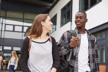 Group Of Students Walking Outside College Buildings