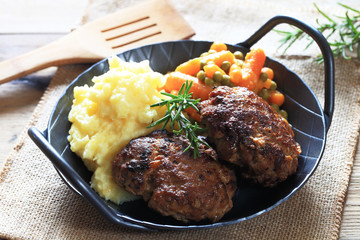 selbst gemachte Frikadellen mit Erbsen, Karotten und Kartoffelpüree