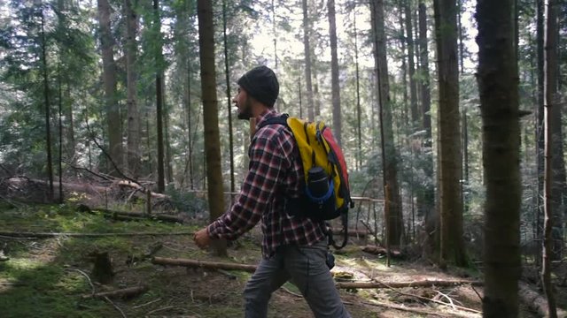 man hiking in the forest with backpack