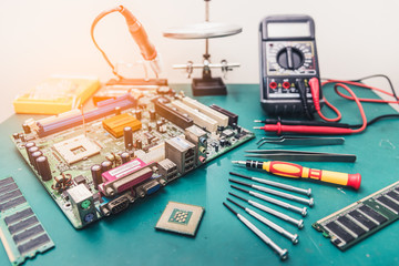 The abstract image of the computer mainboard on the technician's table and put together by repair equipment. the concept of computer hardware, repairing, upgrade and technology.