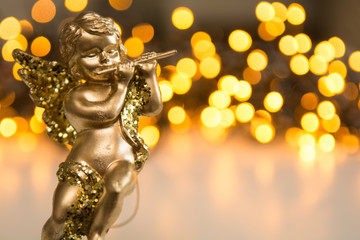 Fototapeta premium Golden christmas cherub figure on shiny white and gold background