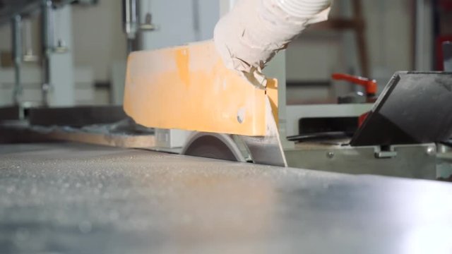 The process of cutting the chipboard on a machine close-up. Furniture manufacture