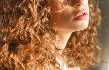 Closeup of lips and curls of a ginger model