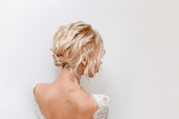 Rear view portrait of attractive young woman with beautiful wedding hairstyle and dress