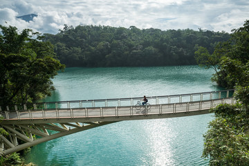 Obraz premium Young woman riding bicycle on Sun Moon lake bike trail