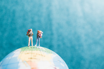 Miniature Backpacker , Travelers with backpack standing on world map and walking to destination