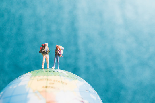 Miniature Backpacker , Travelers with backpack standing on world map and walking to destination
