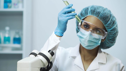 Laboratory worker checking liquids transparency in medical tubes, close-up
