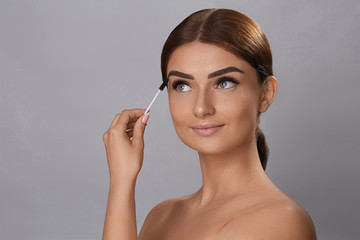 Fototapeta premium Mascara. Beauty Makeup, Fresh Soft Skin And Long Black Thick Eyelashes Applying Mascara With Cosmetic Brush. Eyelashes extensions. Fake Eyelashes.