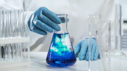 View of conical flask with liquid changing color into blue, biochemistry