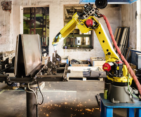 Welding robot in operation / Photo taken in Russia, in factory premises - obrazy, fototapety, plakaty