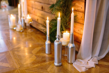 design, interior, arts and crafts concept. on the sparkling parquet of the restaurant hall there are silver bottles by table, they are used for holding tall slim candles