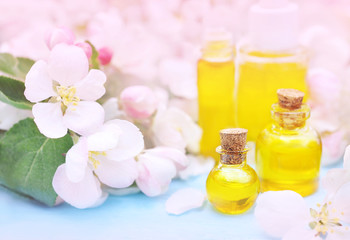 Obraz na płótnie Canvas Essential oils on pink spring flowers background, selective focus, toned