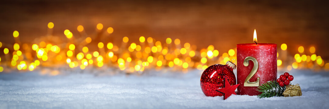 Zweiter Advent schnee panorama Kerze mit Zahl dekoriert weihnachten Aventszeit holz hintergrund lichter bokeh / second sunday advent