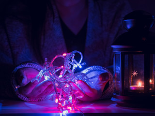 girl(25s to 35s) in the winter cloth hold decoration light and preparation for christmas celebration event with christmas light and black lantern with soft focus background