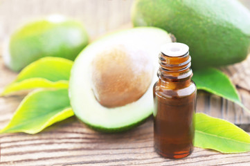 Essential oil on green avocado fruits and leaves background, selective focus