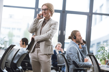 businesswoman with notepad talking on smartphone