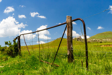 Fototapeta na wymiar An old farm fence and gate sits un maintained and unused on an old farm near the sterkfontein dam, South Africa.