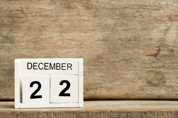 White block calendar present date 22 and month December on wood background