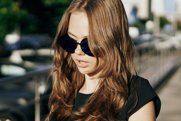 Young beautiful woman in sunglasses on the street in the city, megapolis