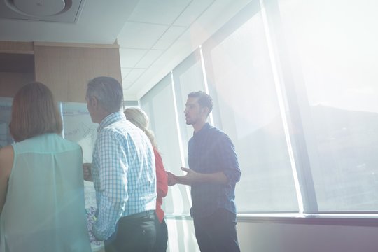 Business colleagues discussing at office during sunny day