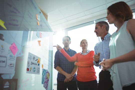 Low angle view of business colleagues discussing over whiteboard