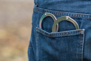 Metal handcuffs in back jeans pocket