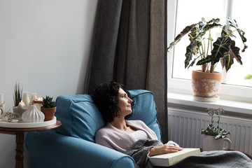 Beautiful woman relaxing on sofa and reading book