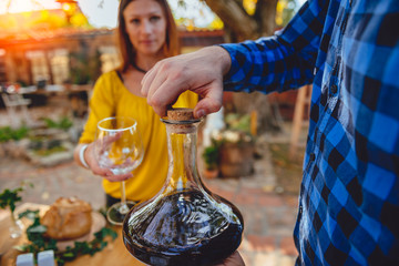 Men holding wine decanter above dining table