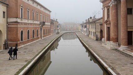 Fototapeta na wymiar Comacchio (Italy) - Characteristic and fascinating historic town in the Park of the Po Delta, Comacchio has a maze of canals with small bridges and pastel-coloured houses.