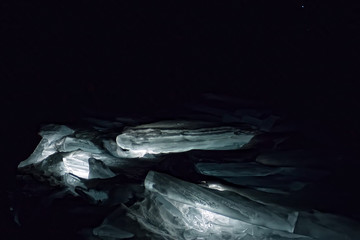 Luminous hummocks of the blue ice of Lake Baikal in the dark