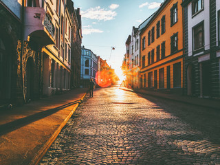 Man walking alone at sunset street Travel Lifestyle concept vacations cobblestone road city in Norway