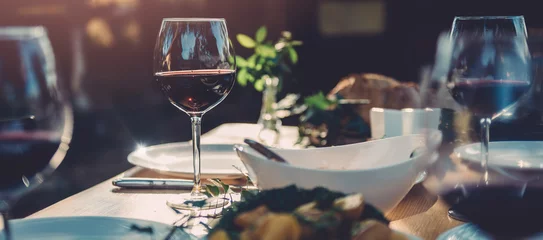 Rolgordijnen Glass of wine at dining table © kerkezz