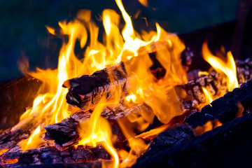 The blazing flames from the hot coals in the barbecue