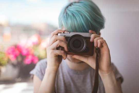Woman taking picture from camera at home