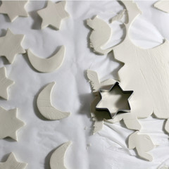 Making homemade Christmas decorations with white clay and cookie cutters. Selective focus.