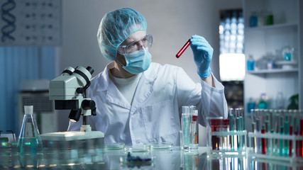 Laboratory worker studying blood samples to detect pathologies, medical research