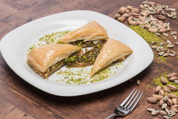 Baklava with pistachios, walnuts and honey on wooden background.