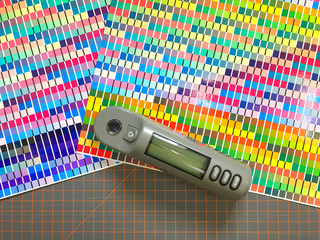Color chart with measurement tool. Checking colors with equipment. Printing factory tools.
