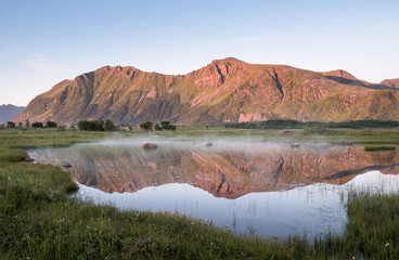 Fototapeta na wymiar Scenic mountain landscape with nice reflection at bright summer day in Lofoten Island, Norway