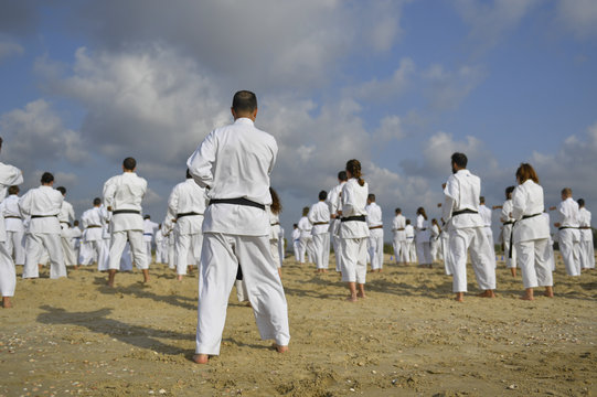 Karate fighters practicing on the sea beach