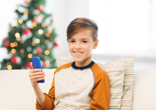 boy playing on smartphone at home at christmas