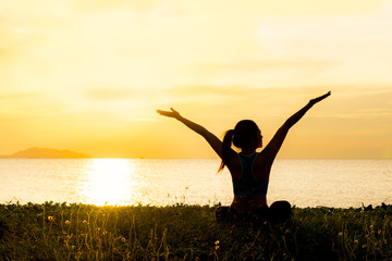 Meditation yoga lifestyle woman silhouette on the Sea sunset, relax vital.  Healthy Concept