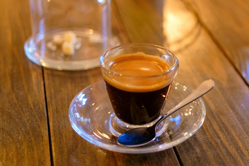 espresso coffee in transparent cup on a wooden table