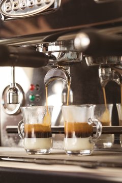 Coffee being poured into two coffee mugs