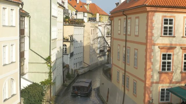 A boat is passing on a small Vltava river man builded channel.