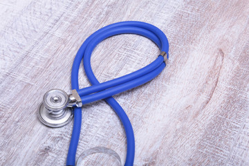 Closeup of a medical stethoscope, isolated on wooden background